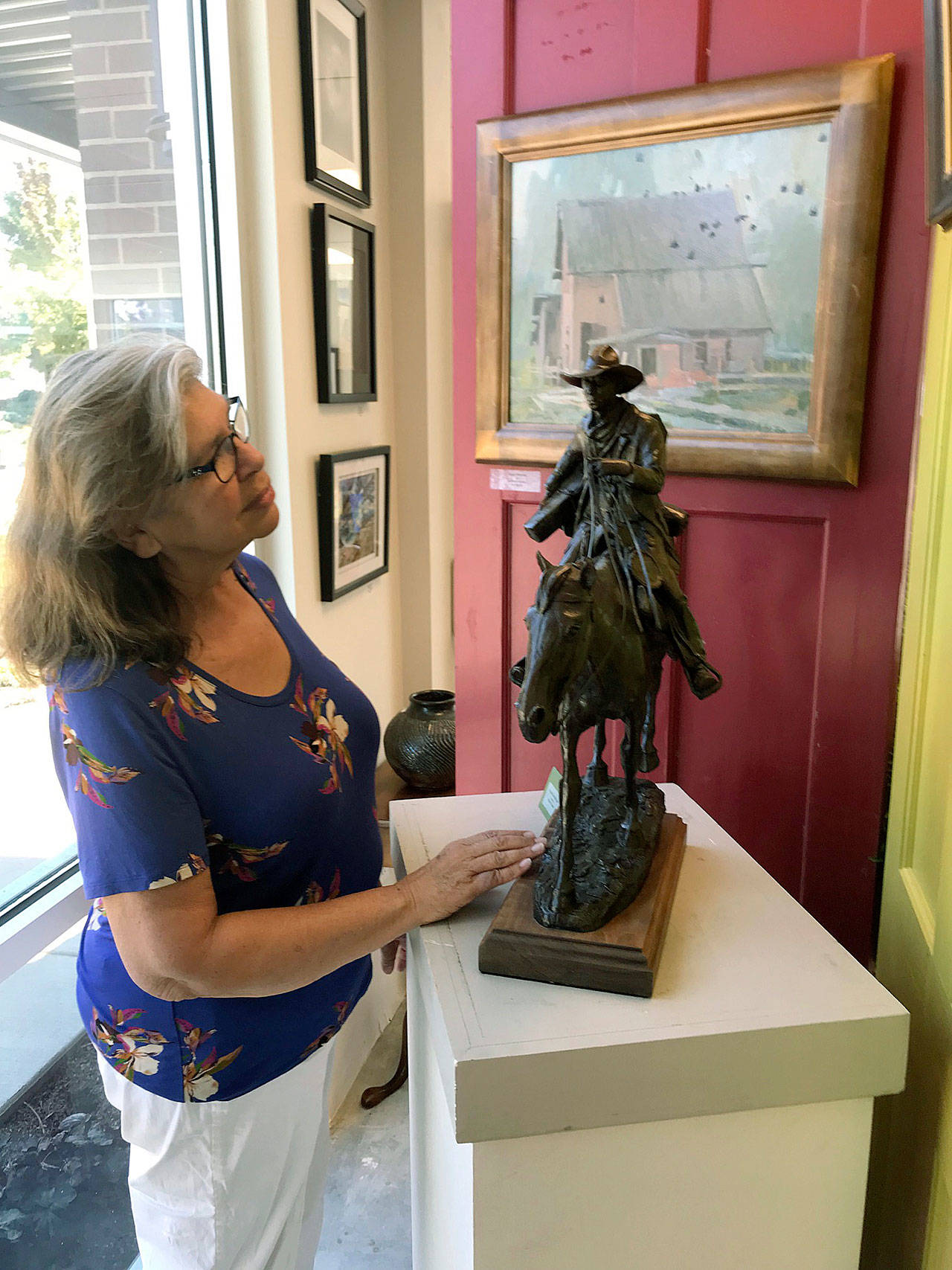 Charlotte Gollnick, a member of Auburn Valley Creative Arts, takes in some of the local works on display at the group’s recently-opened “pop-up” gallery at The Villas at Auburn, a new apartment complex. MARK KLAAS, Auburn Reporter