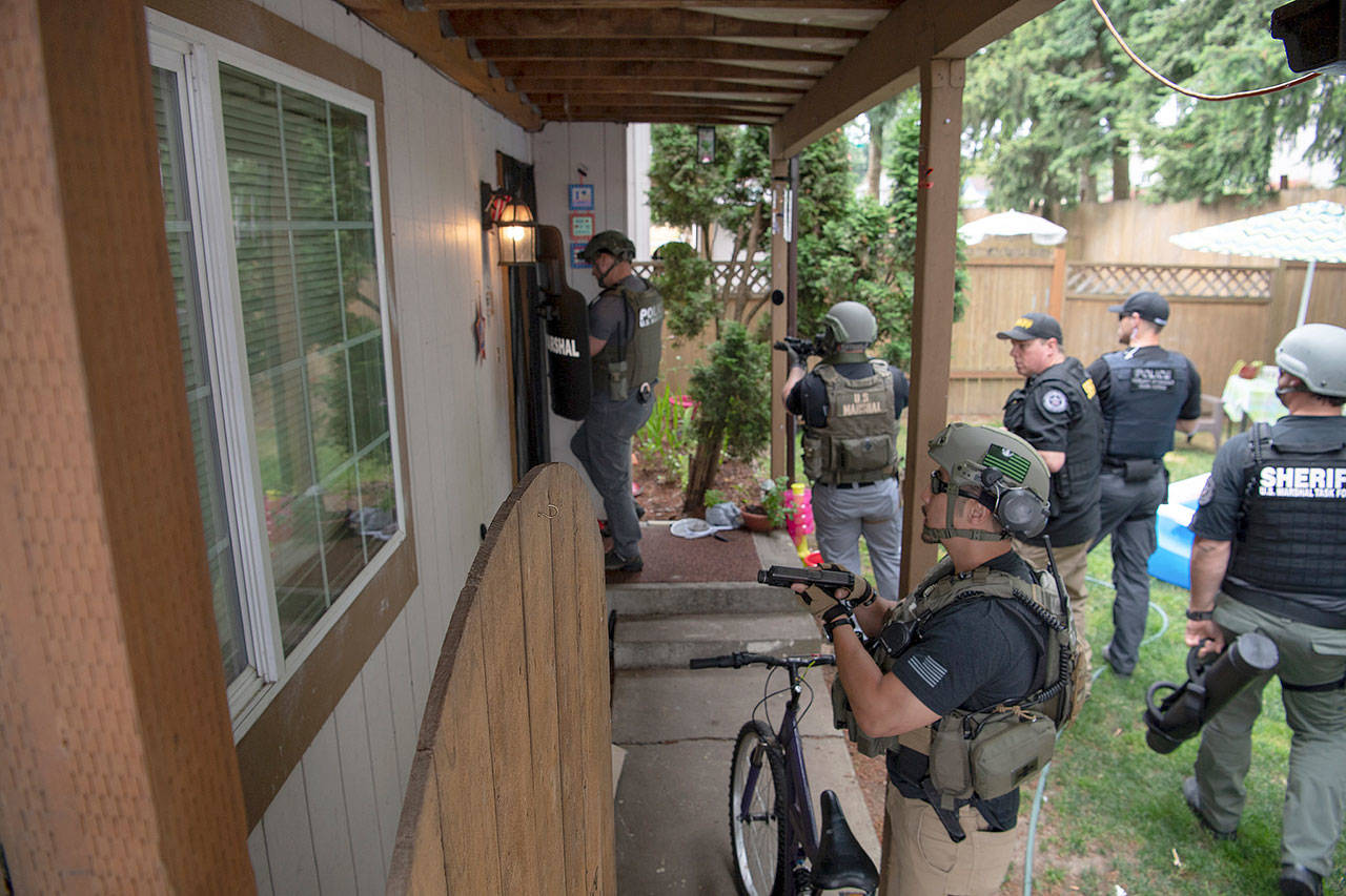 Task force members get ready to raid a house at an unspecified location in July during a crackdown on gang members. COURTESY PHOTO, U.S. Marshals Service