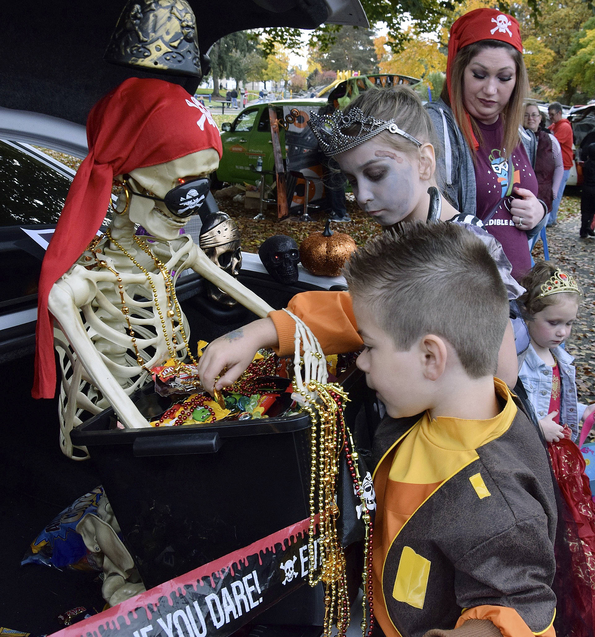 Krystal Sanders as a pirate has Shaylee Bonzan, 9, and Landon Gregory, 7, get candy from the treasure chest. RACHEL CIAMPI, Auburn Reporter