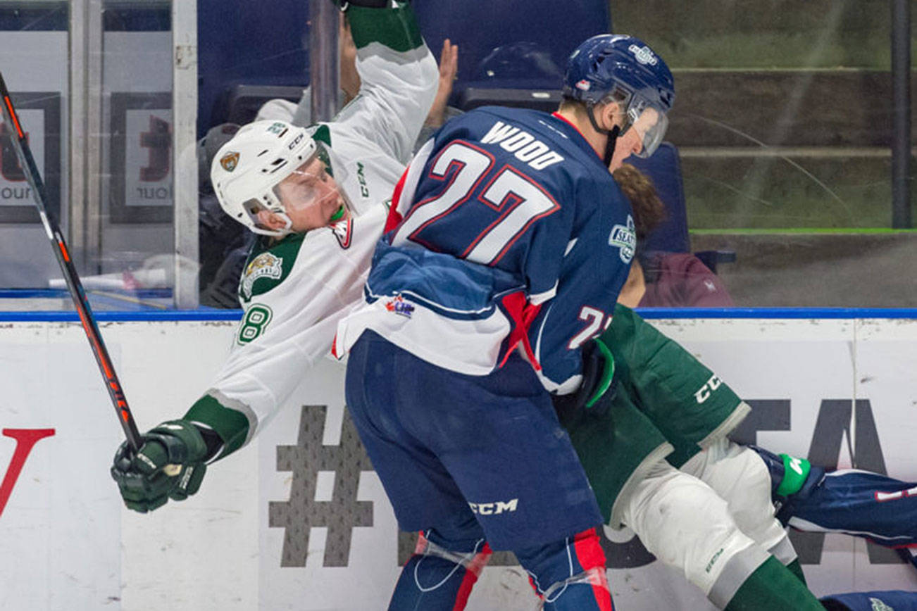 The Thunderbirds’ Wood checks the Silvertips’ Conrad Mitchell into the boards during WHL play Saturday night. COURTESY PHOTO, Brian Liesse, T-Birds