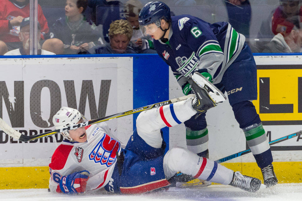 Thunderbirds defenseman Tyrel Bauer knocks the Chiefs’ Jack Finley to the ice during WHL play Tuesday night. COURTESY PHOTO, Brian Liesse, T-Birds