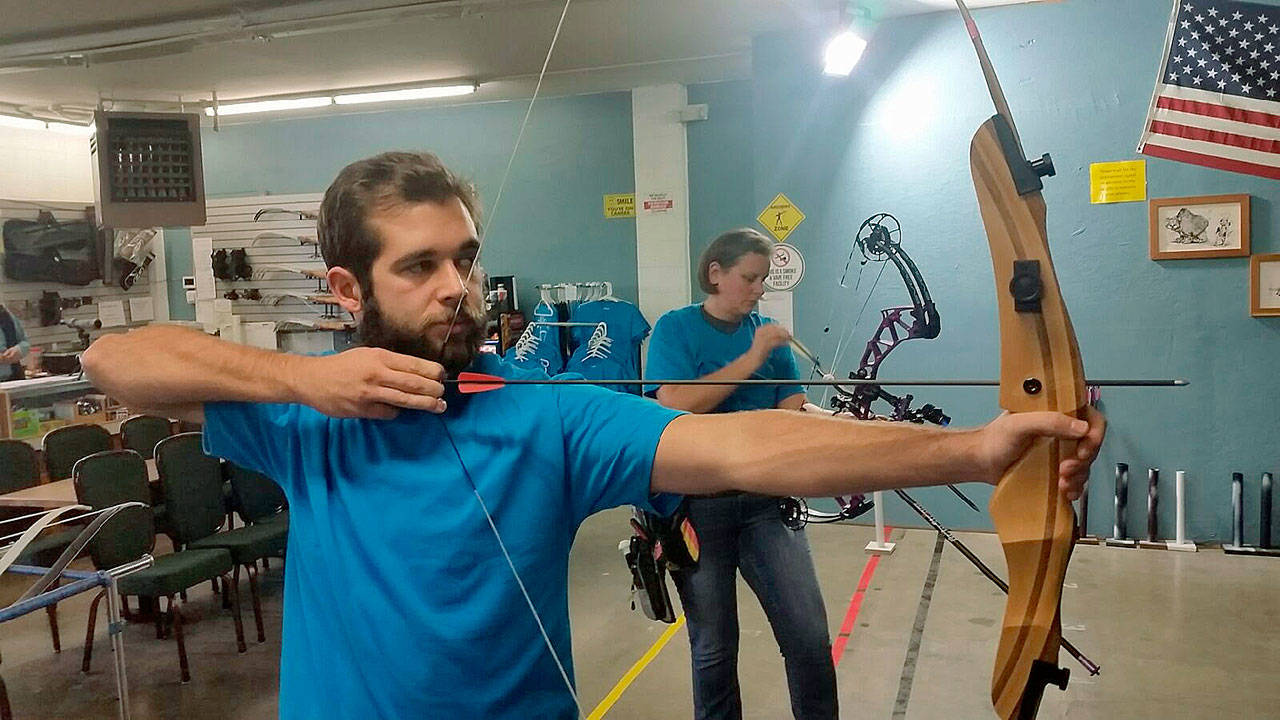 Luke Giannoulas, co-owner with his father, Ted, of the Orion Indoor Archery Range on Auburn Way North, demonstrates how an expert wields the re-curve bow on a recent day. ROBERT WHALE, Auburn Reporter