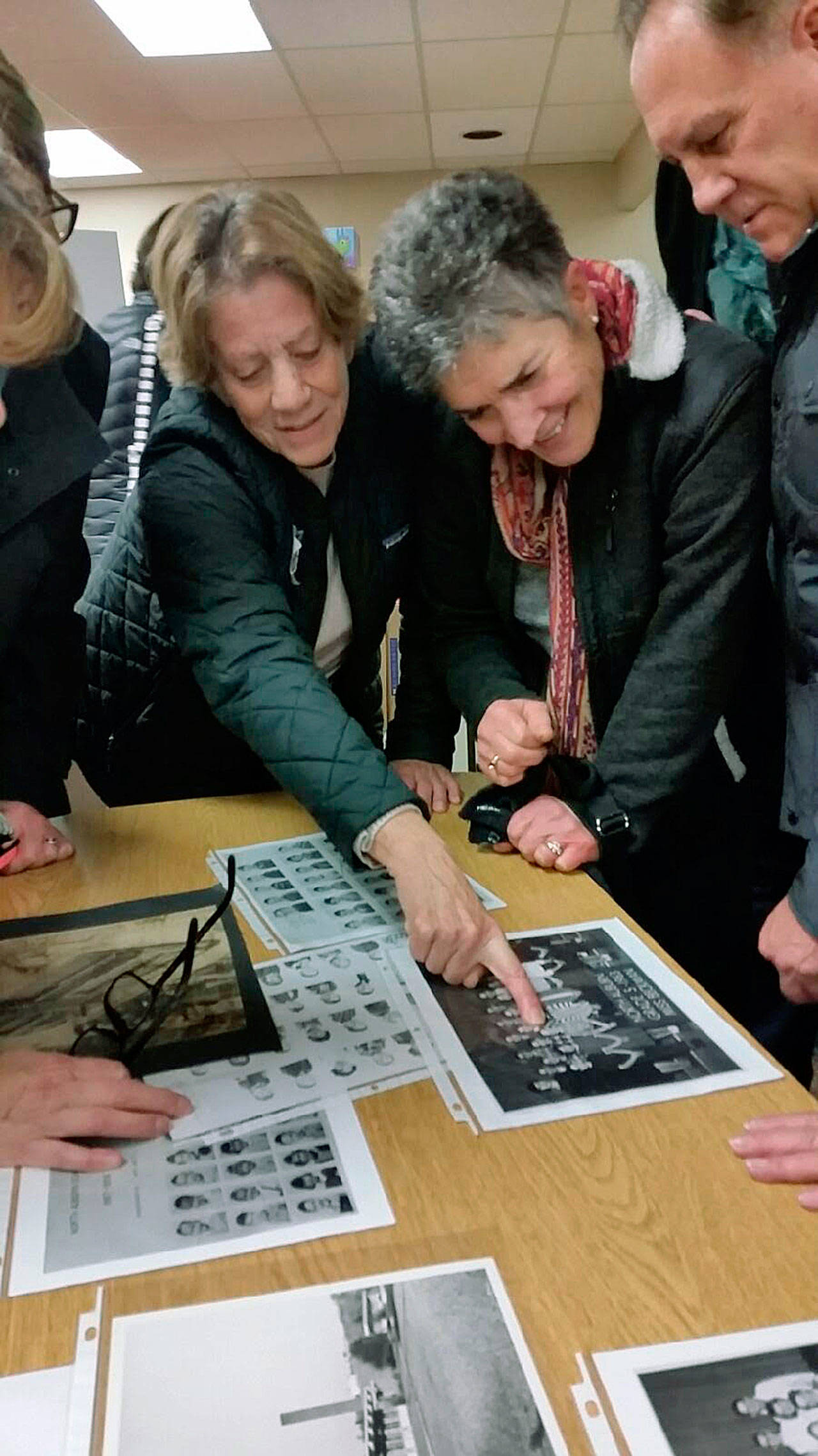 Chris Edwards and Mary Fioretti, school chums of common vintage, find a familiar face and common memory in a class photograph during a final visit to their old elementary school, North Auburn, last Saturday night. ROBERT WHALE, Auburn Reporter