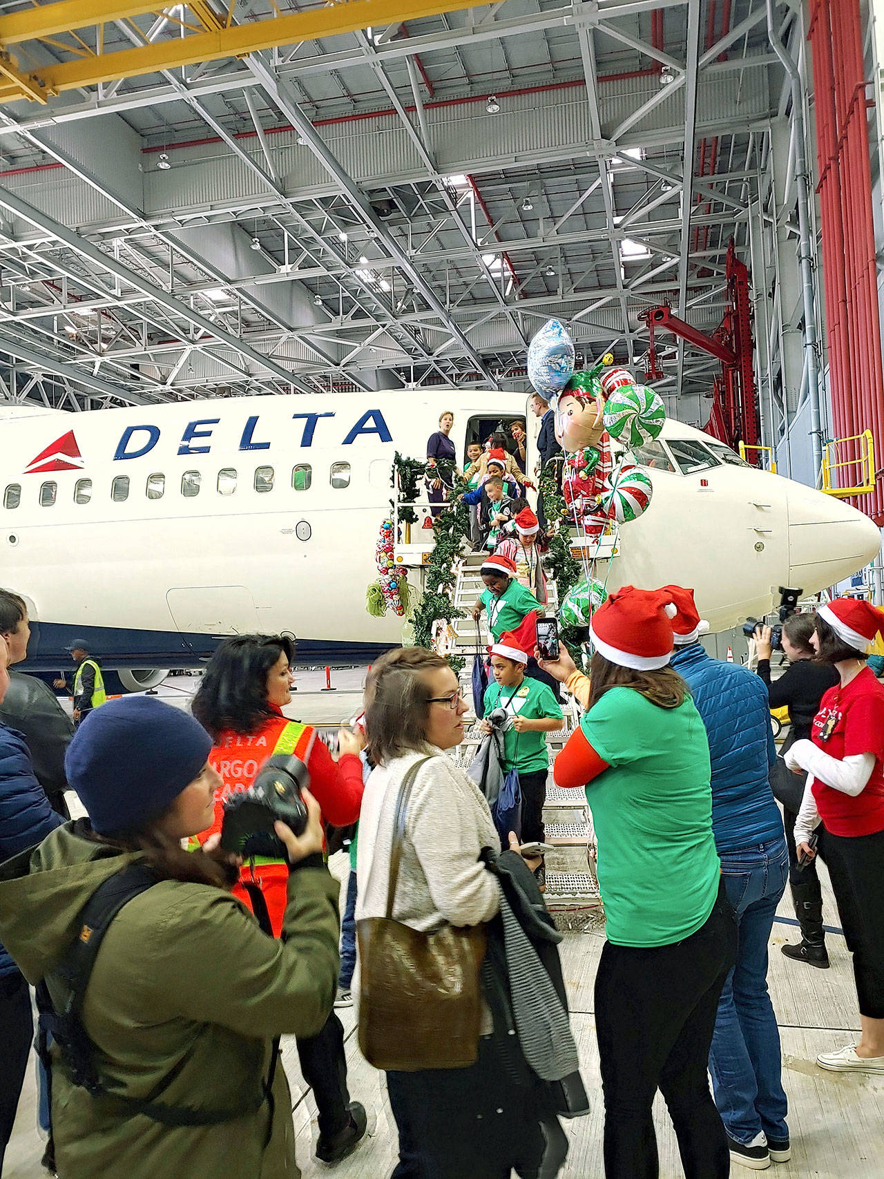 Excited Washington Elementary School second-graders descend into a Delta Air Lines hanger-turned-North Pole at Sea-Tac Airport on Tuesday afternoon, where presents, Santa and Mrs. Claus and all kinds of goodies awaited them, courtesy of Delta Air Lines and the Seattle YMCA. COURTESY PHOTO