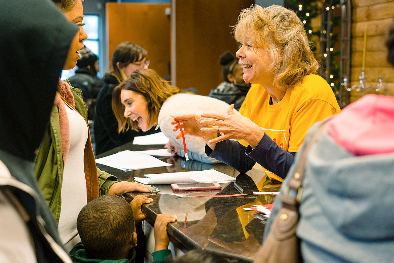 Volunteer staff greet families during the ‘Smiles at Christmas,’ a free holiday toy giveaway event at Overcomer Covenant Church on Auburn’s West Hill last Saturday. COURTESY PHOTO, Brandon Patoc