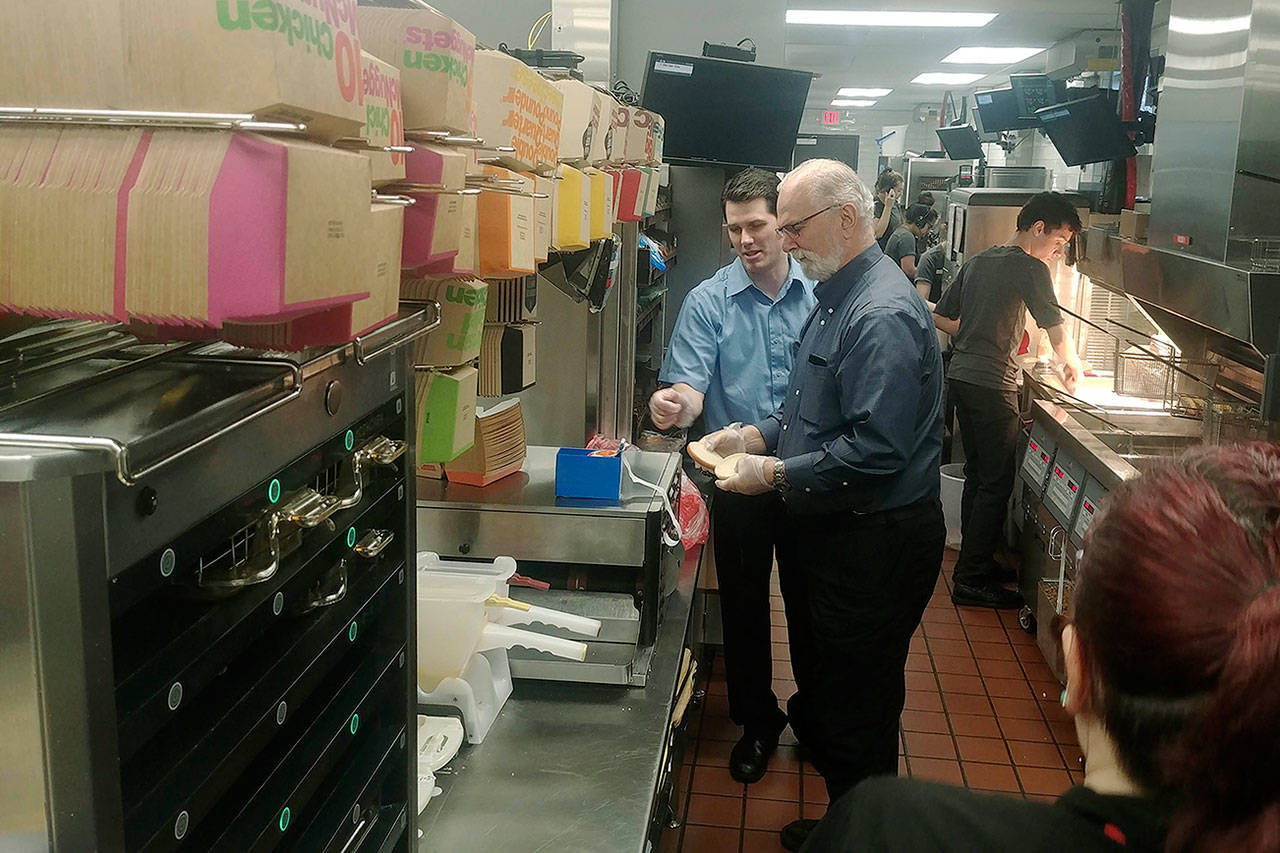 Sen. Phil Fortunato, R-Auburn, gets some instructions in the kitchen from Enumclaw McDonald’s franchisee Alex Medeiros. COURTESY PHOTO