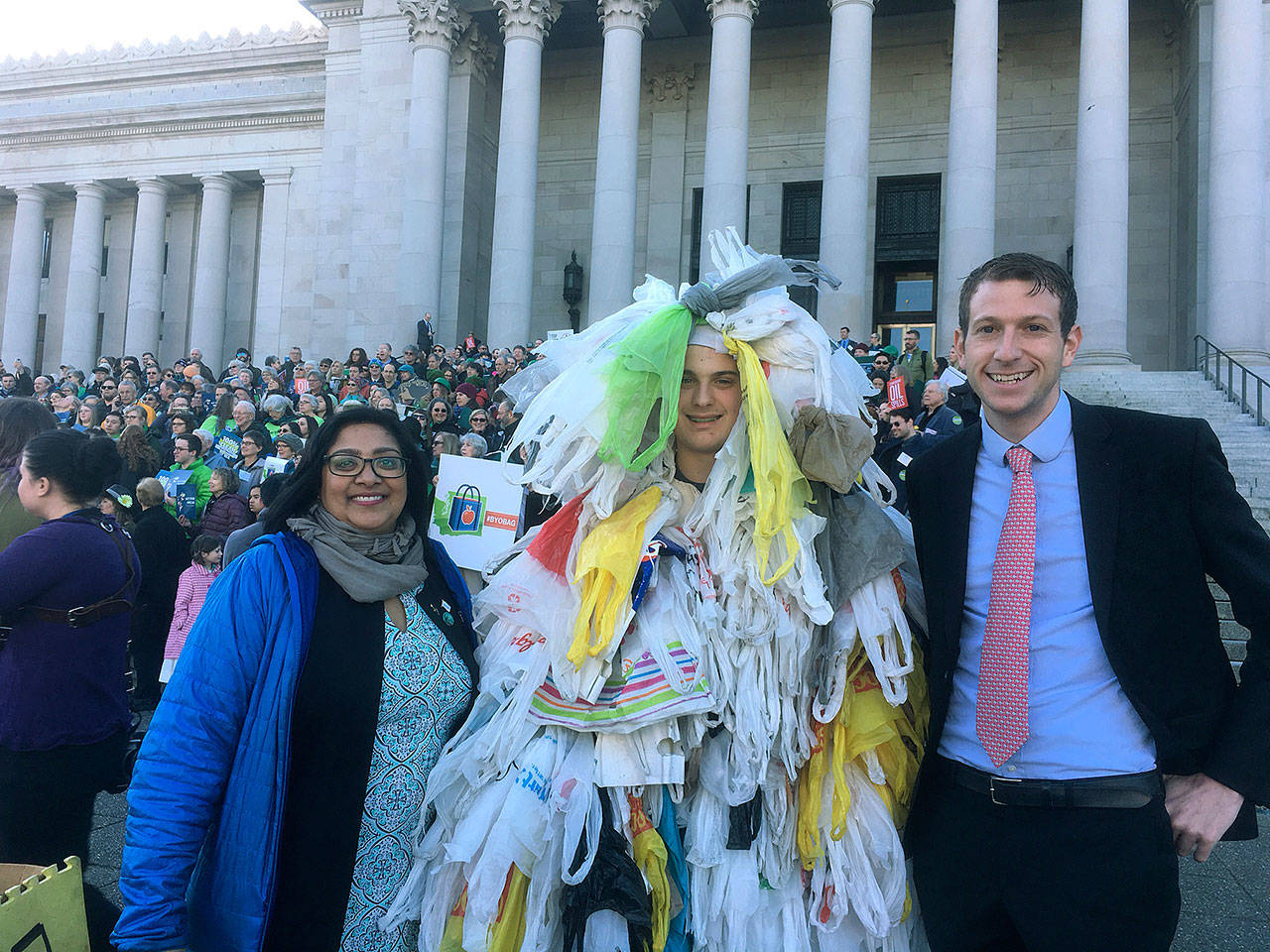 Sen. Mona Das and Rep. Joe Fitzgibbon with the “Bag Monster” on the steps of the Capitol Building in Olympia. COURTESY PHOTO