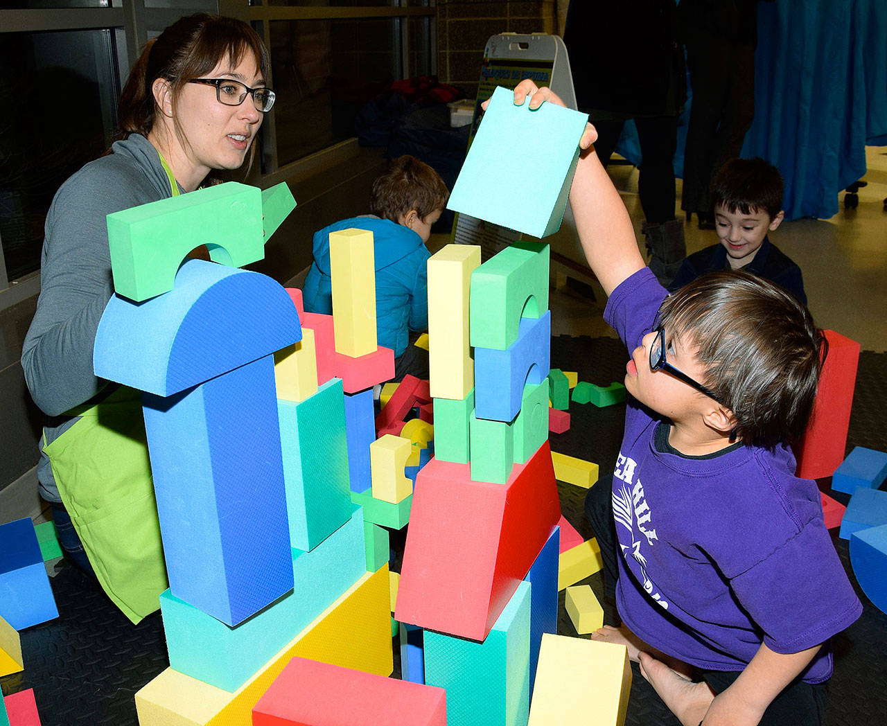 Rachael Zilliott, a pre-K helper, watches as Max Froman, 7, builds a block tower during the Early Learning. RACHEL CIAMPI, Auburn Reporter