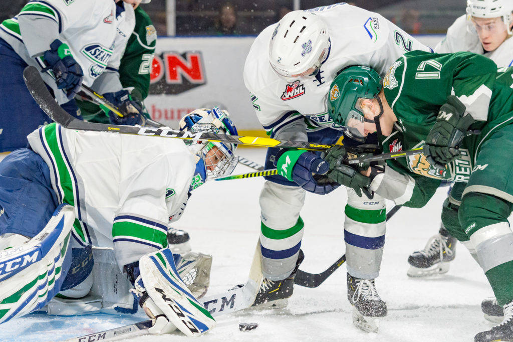 Thunderbirds defenseman Simon Kubicek (2) and the Silvertips Jackson Berezowski (17) battle for position as Seattle goalie Roddy Ross prepares to smother the puck during WHL play Saturday night. COURTESY PHOTO, Brian Liesse, T-Birds