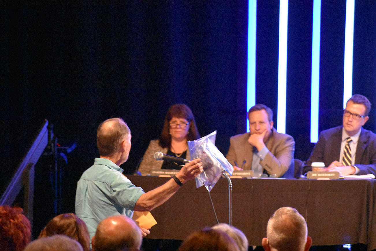 A man addresses the King County Council during a public hearing March 20 at New Life Church in Renton. He presented bags filled with what he said was hazardous materials dropped on his property by bald eagles. Another speaker made similar claims. Haley Ausbun/staff photo