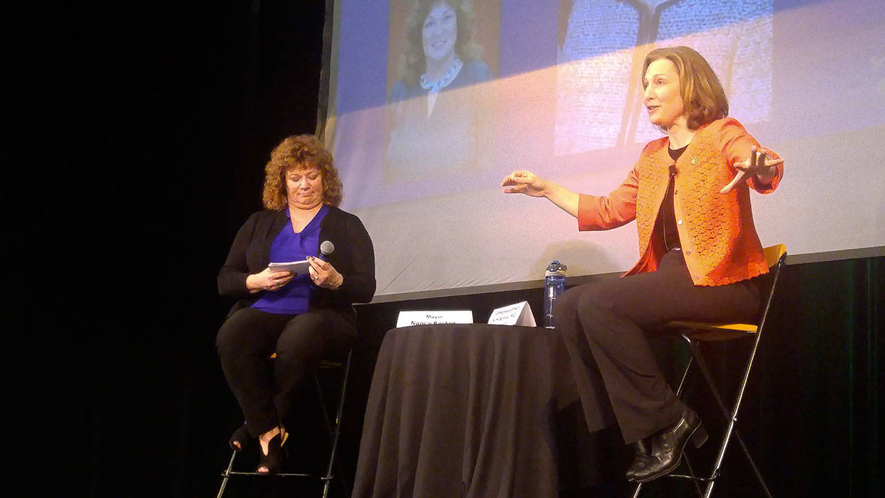 U.S. Rep. Kim Schrier, right, answers questions submitted to her by constituents and collected by Auburn Mayor Nancy Backus, left, during her town hall appearance at Green River College on April 17. ROBERT WHALE, Auburn Reporter