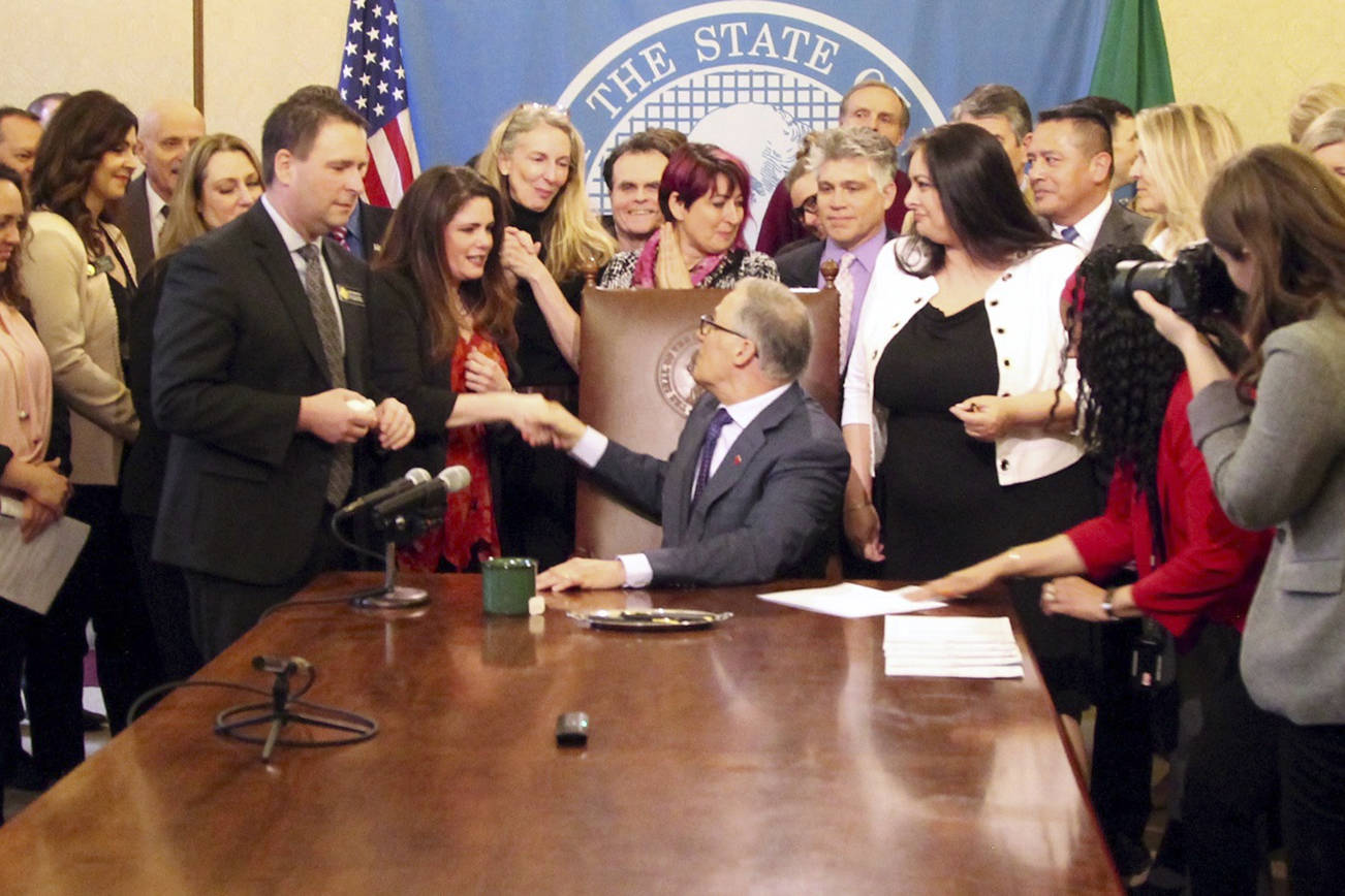Gov. Jay Inslee shakes hands with Dinah Griffey after signing Senate Bill 5649 on April 19. The law revises the statute of limitations for sex crimes. Photo by Emma Epperly, WNPA Olympia News Bureau