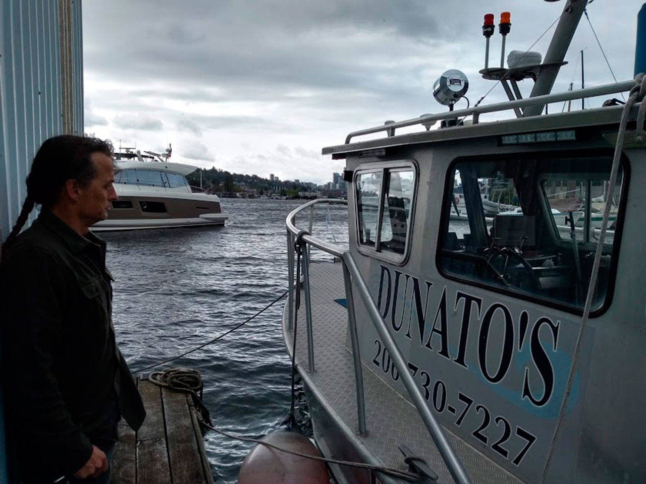 Corey Breuer, owner of Northwest Boat Disposal at Dunato’s Boat Yard in Seattle shows a reporter one of three vessels which can lift sunken boats from King County waters and Puget Sound. Aaron Kunkler/staff photo