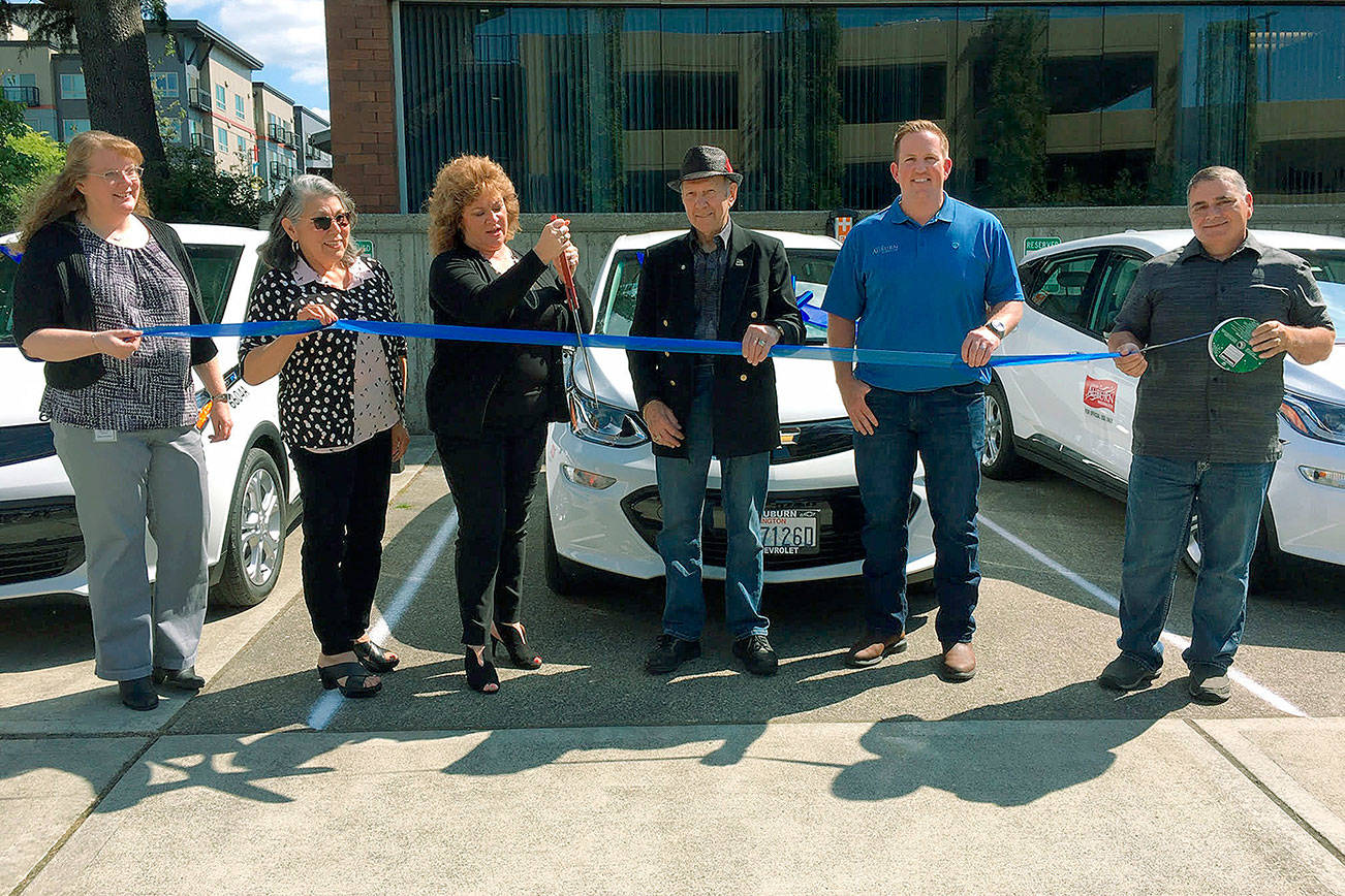 Staff, council members and Mayor Nancy Backus welcome into the city’s fleet its first four, all-electric cars during a ribbon-cutting ceremony last week. COURTESY PHOTO, city of Auburn.
