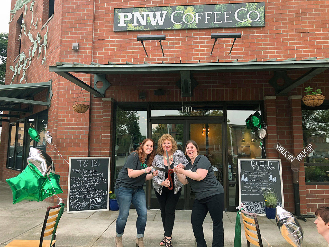 Jenniffer Trinidad, far right, and Connie Krier, left – owners of PNW Coffee Co. (formerly 2 Sisters Espresso) – join Auburn Mayor Nancy Backus for a ribbon cutting Thursday at their new Auburn café by the train station. COURTESY PHOTO