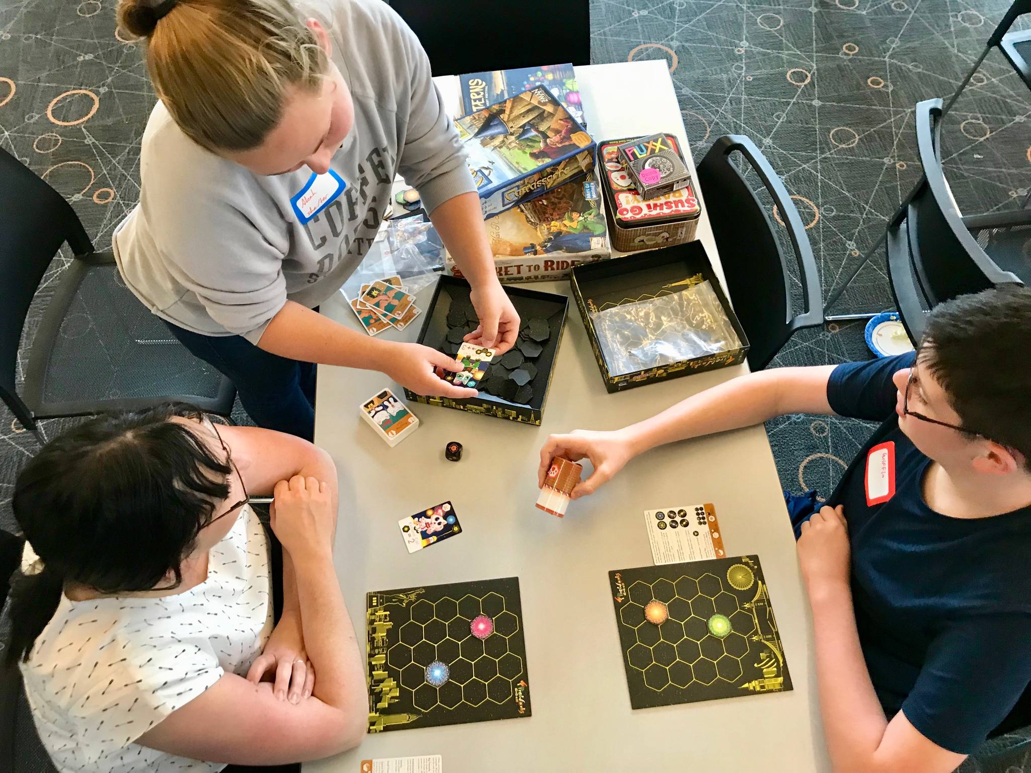 Aleah Adams, of Federal Way-based Fantasium Comics and Games, shares her game, Fireworks, to players during Teen Game Night on Thursday, June 6 at the Auburn Library. MARK KLAAS, Auburn Reporter