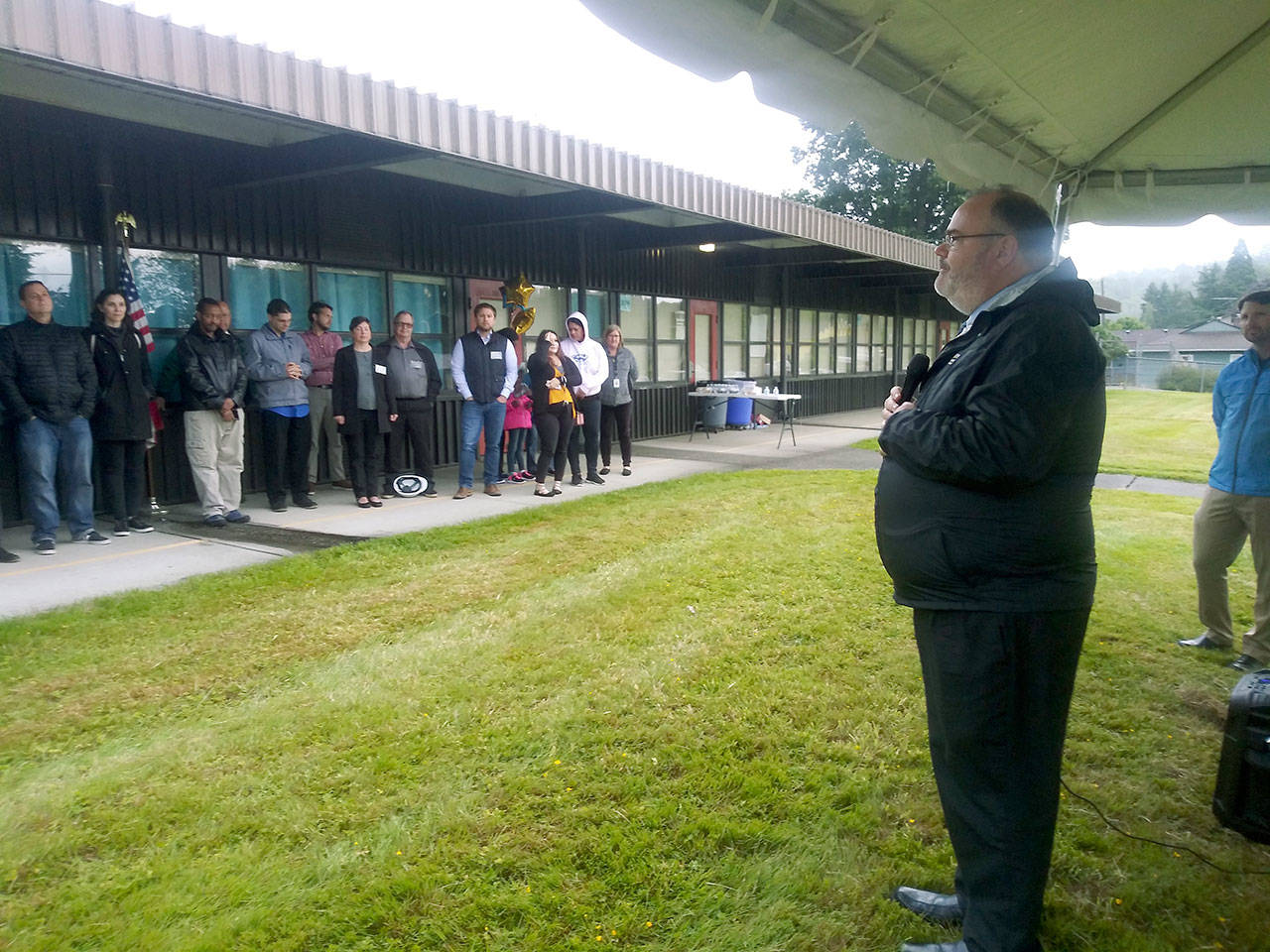 Auburn School District Superintendent Alan Spicciati addresses a crowd under cover from the rain during a groundbreaking ceremony for the new Dick Scobee Elementary School last Friday. The new school, which will replace the old one at the same location, is scheduled to open in 2020. ROBERT WHALE, Auburn Reporter