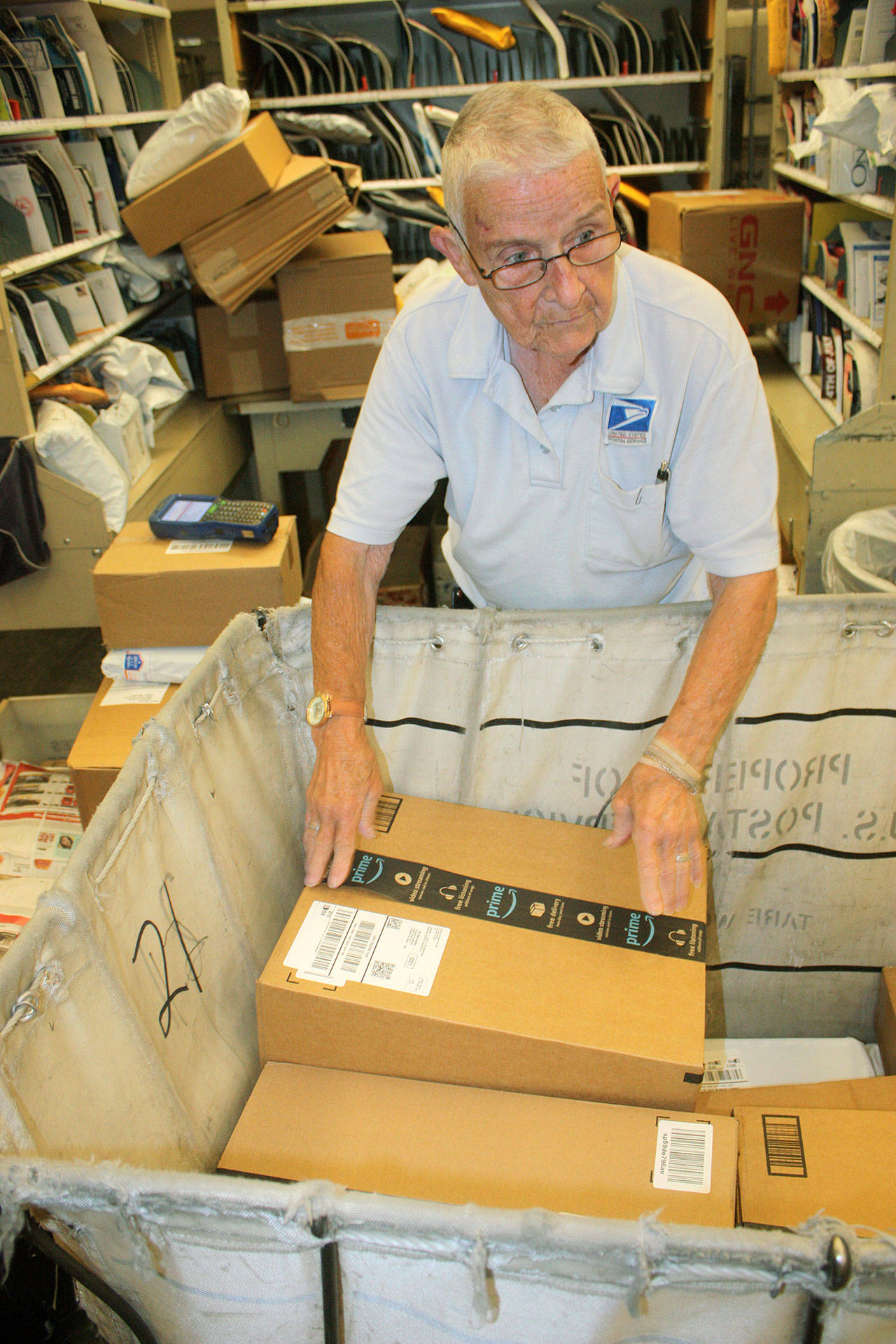 Myrna Ransier arranges packages for delivery at her workstation at the Auburn Post Office. MARK KLAAS, AUBURN REPORTER
