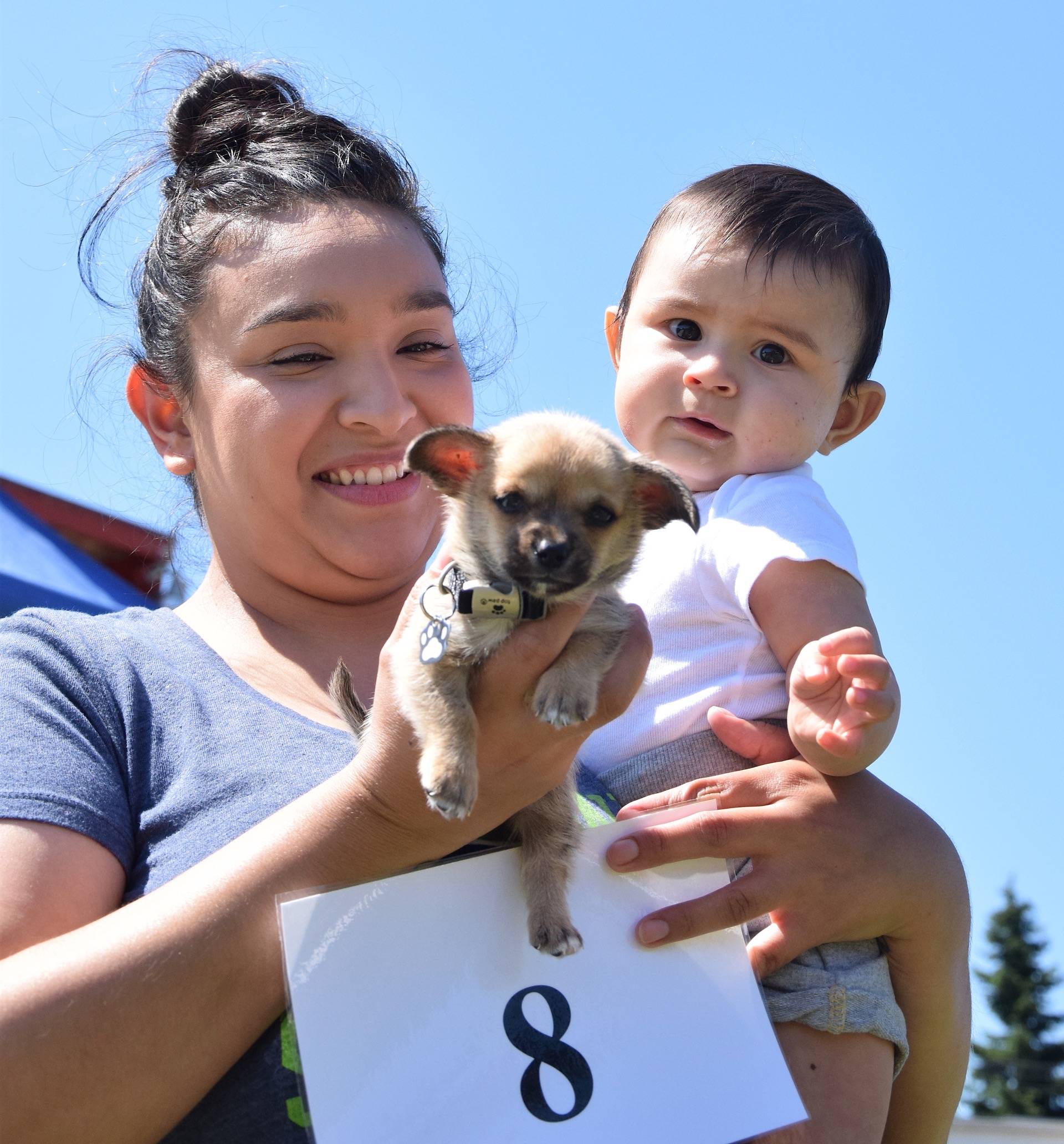 Andrea Serna and her son, Ezio, 7 months, walk their dog, Bleu, 6 weeks, in the dog show at the Auburn International Farmers Market on Sunday. RACHEL CIAMPI, Auburn Reporter