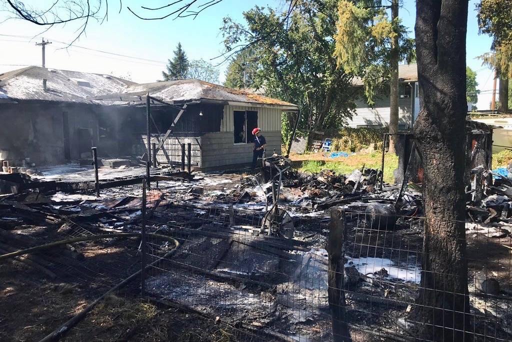 Firefighters sift through the ruins of a Pacific home fire Monday. COURTESY PHOTO, VRFA