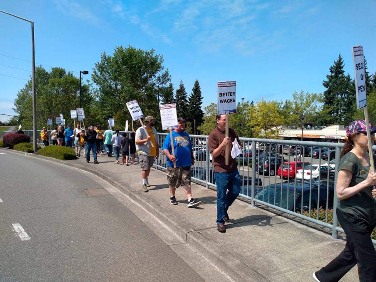 Grocery store union workers picket outside of a Bellevue QFC on July 31. They are in contract negotiations with Kroger for higher wages, predictable scheduling and better safety conditions. Aaron Kunkler/staff photo