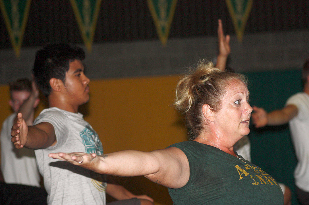 Katie Henry, Auburn High School athletics director and certified yoga instructor, leads a class of about 75 student-athletes through the many poses of the discipline Monday morning inside the school’s wrestling gym. MARK KLAAS, Auburn Reporter