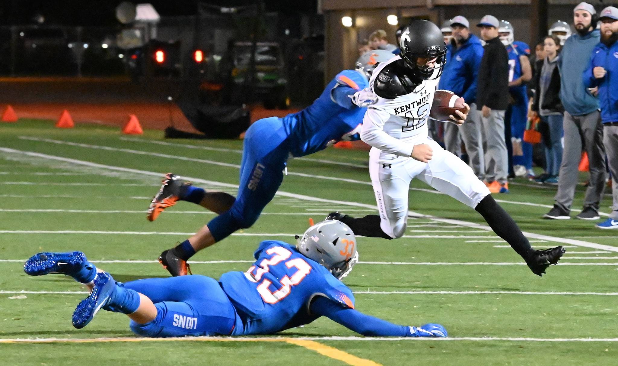 Kentwood quarterback Jackson Proctor dashes goal-ward as Auburn Mountainview’s Teagin Child and Cooper White (33) pursue during NPSL first-half play Friday night. RACHEL CIAMPI, Auburn Reporter