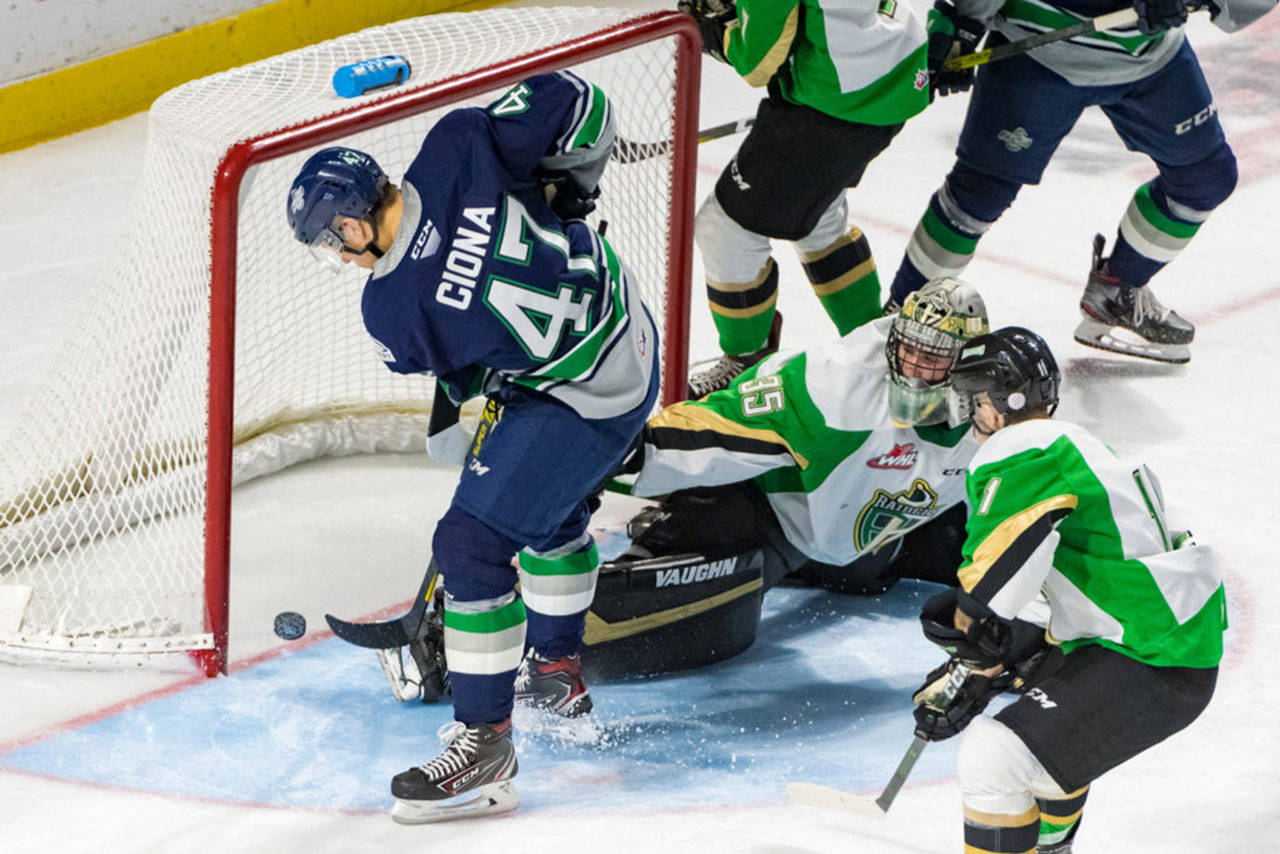 The Thunderbirds’ Lucas Ciona pushes the puck past Raiders goalie Boston Bilous for his first career WHL goal Tuesday night. COURTESY PHOTO, Brian Liesse, T-Birds