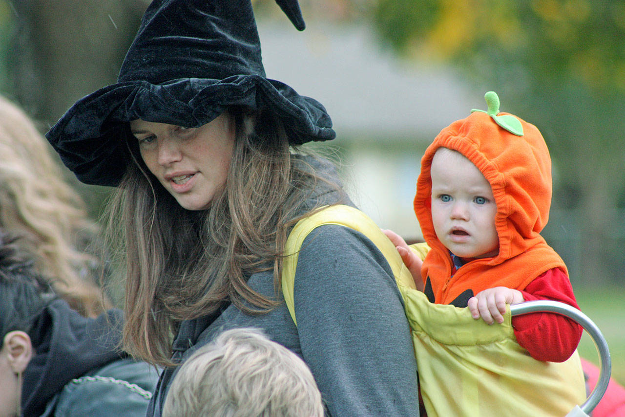 Alyssa Johnson shops for treats and things with her 1-year-old son, Wesley, in tow during the Halloween Harvest Festival and Les Gove Park Trunk-or-Treat event last Saturday. MARK KLAAS, Auburn Reporter