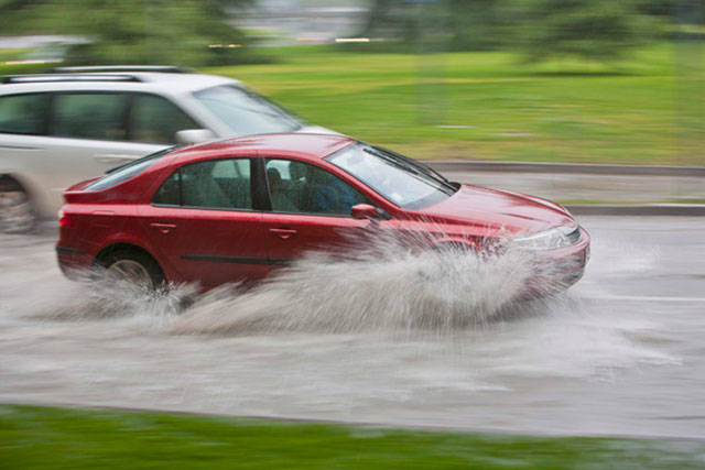 Vehicles passing through flooded street. File photo