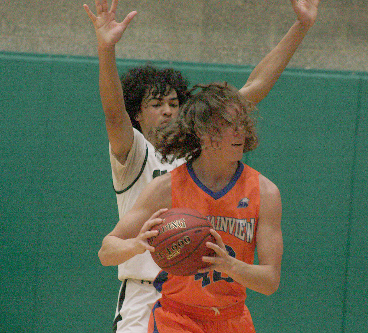 The Trojans’ Darrell Hester, left, battles the Lions’ Brandon Miguel down low during NPSL Olympic play on Friday. MARK KLAAS, Auburn Reporter