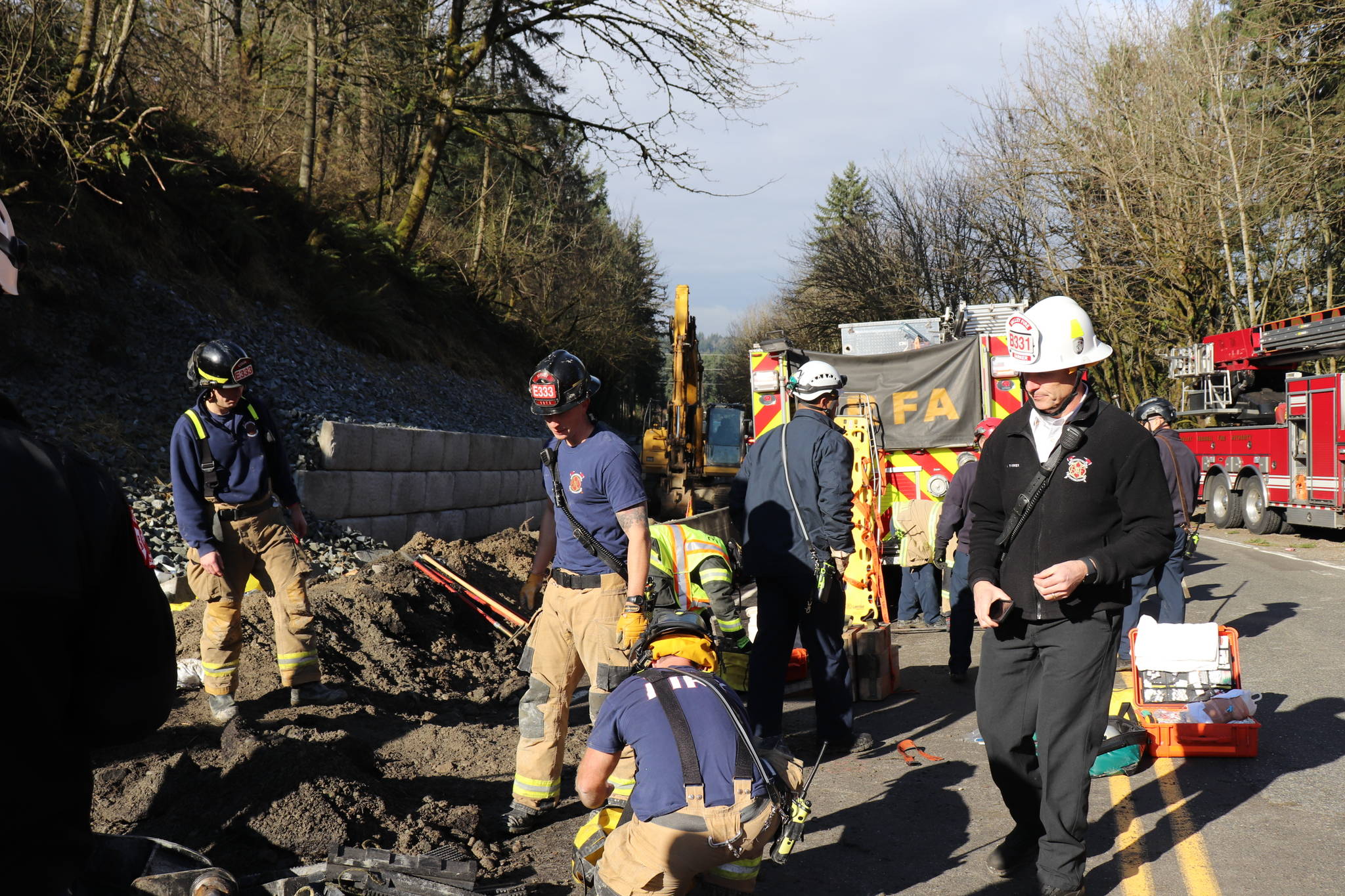 Firefighters work the scene after rescuing a man who was buried to his waist in rock and first when a portion of a retaining wall reportedly collapsed. COURTESY PHOTO, VRFA