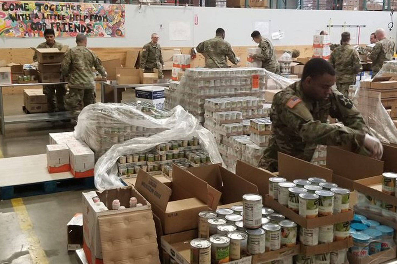 Members of the National Guard pack food boxes last month at the Northwest Harvest warehouse in Kent for distribution to food banks. COURTESY PHOTO, Northwest Harvest