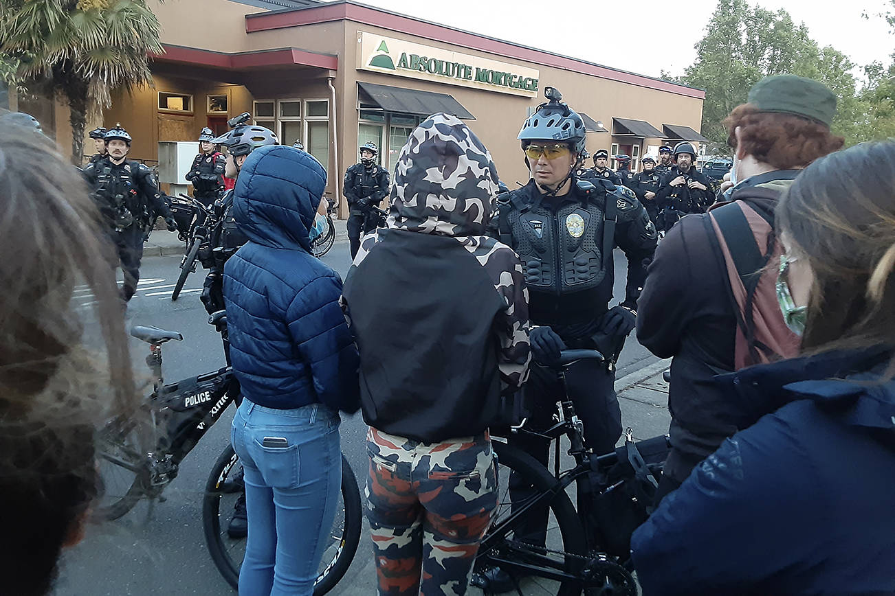 Protesters confront Auburn police Tuesday evening in downtown Auburn. Photo by Robert Whale/Auburn Reporter