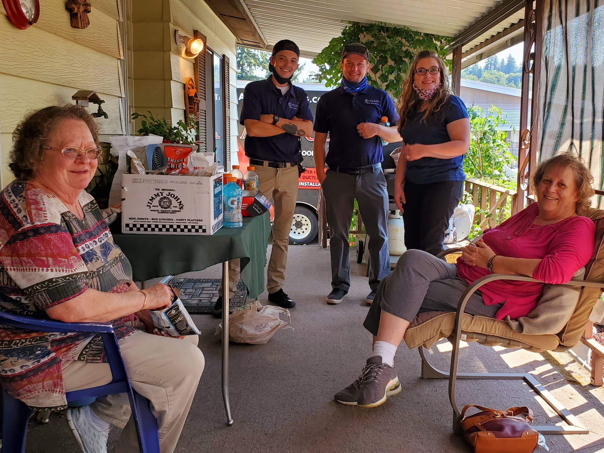 Donna Goodman, left, is all smiles after a crew from Allred showed up at her home en masse to replace her defunct heating and cooling system with a brand new one for free last Thursday. With her on the porch from left to right are Nick Allred, Dan Allred and Amy Shrake of Allred, and to the right is Goodman’s friend and neighbor, Karen Shepherd. Courtesy photo