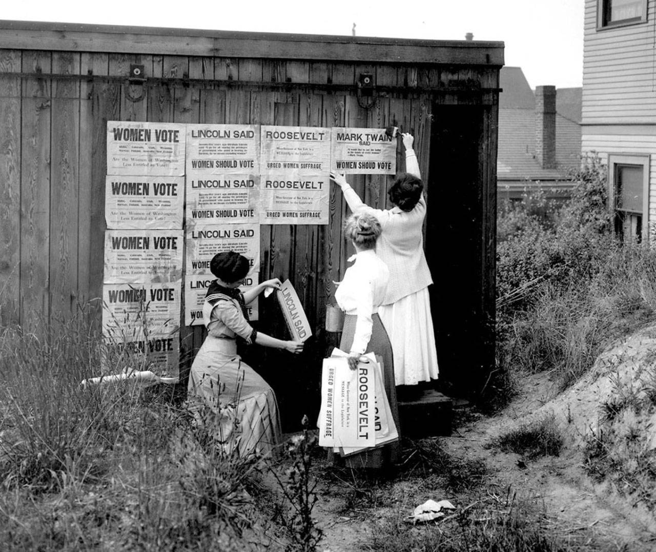 The Washington Equal Suffrage Association places posters in Seattle in 1910 to promote women’s suffrage. (Washington State Archives)