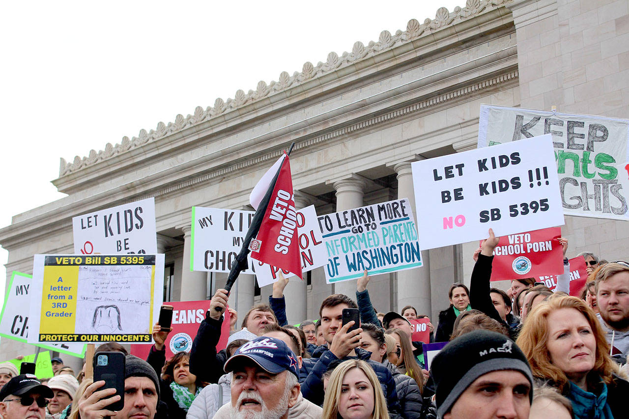 Protesters hold signs advocating a veto on Senate Bill 5395 earlier this year. WNPA News Service