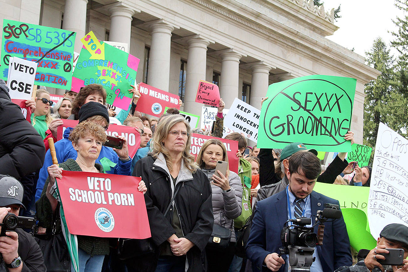 WNPA News Service                                Dissatisfied residents hold signs in protest of comprehensive sex education mandate earlier this year.