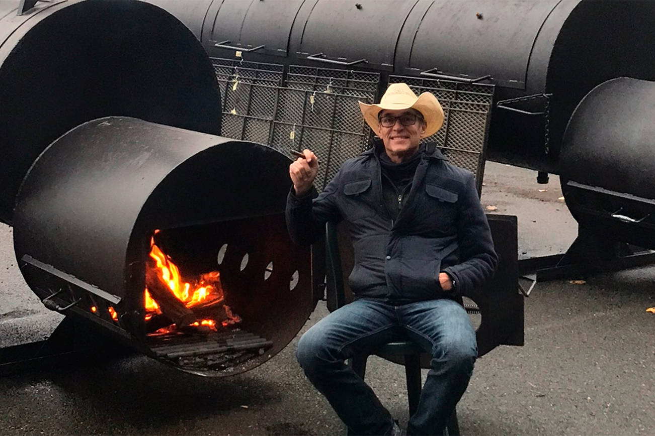 Jack Timmons pauses for a smoke next to his two giant smokers at Jack’s BBQ, which he opened last week on West Valley Highway in Algona.