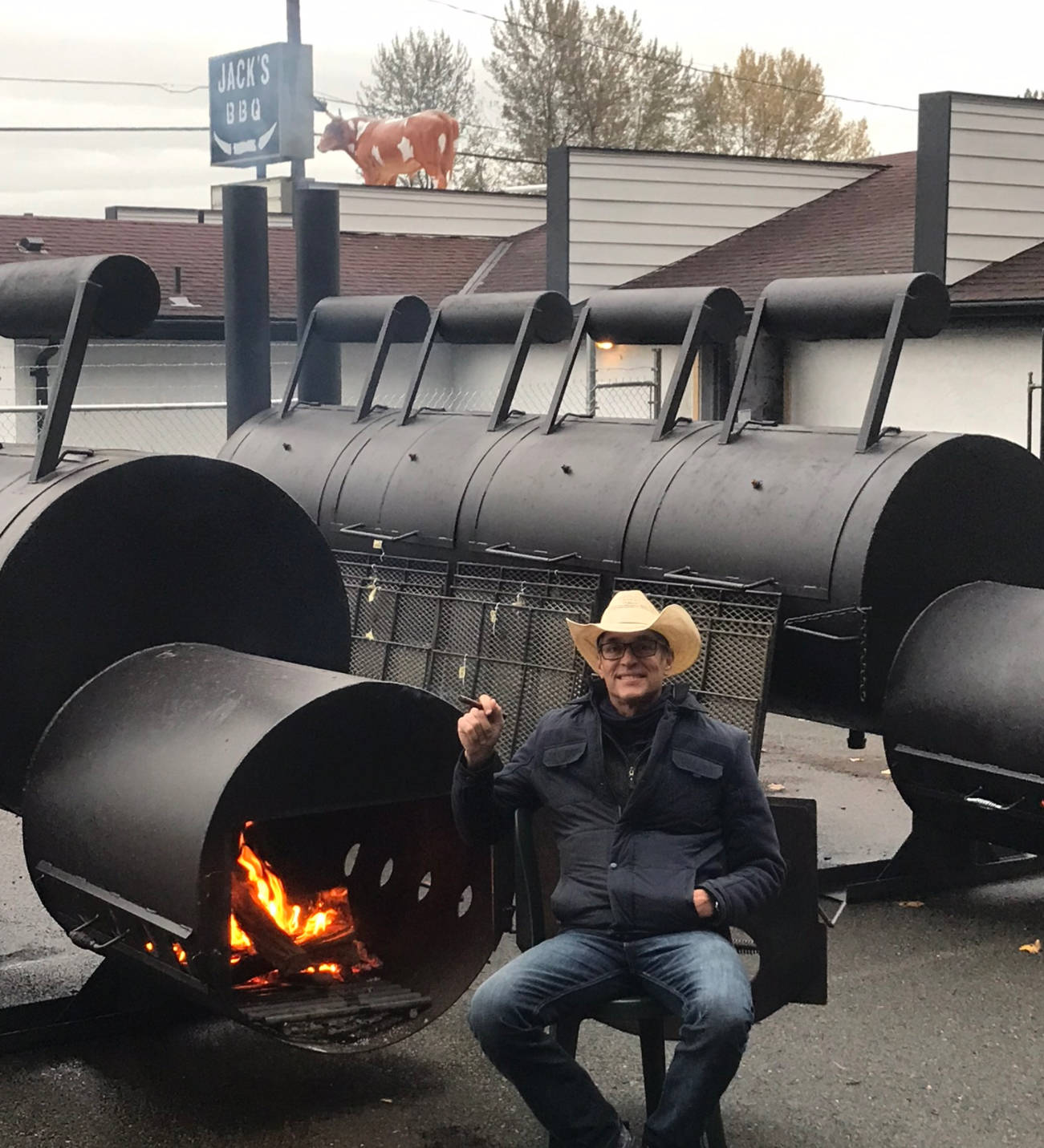 Jack Timmons pauses for a smoke next to his two giant smokers at Jack’s BBQ, which he opened last week on West Valley Highway in Algona.