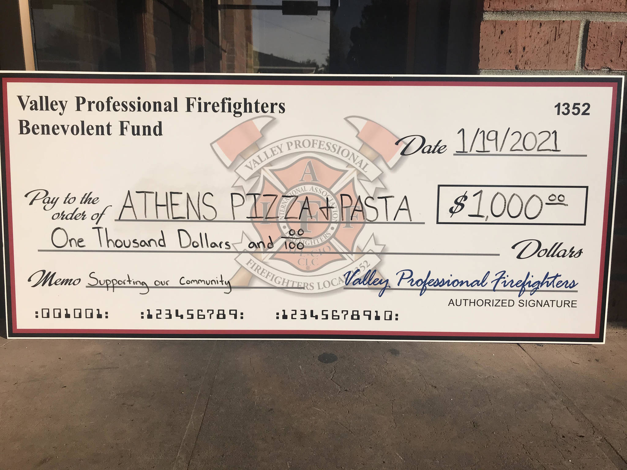 Firefighters on Tuesday donated $1,000 to Athens Pizza and Pasta to help the restaurant continue to pay its employees until it can reopen after effecting necessary repairs following the December fire. Photo courtesy city of Auburn.