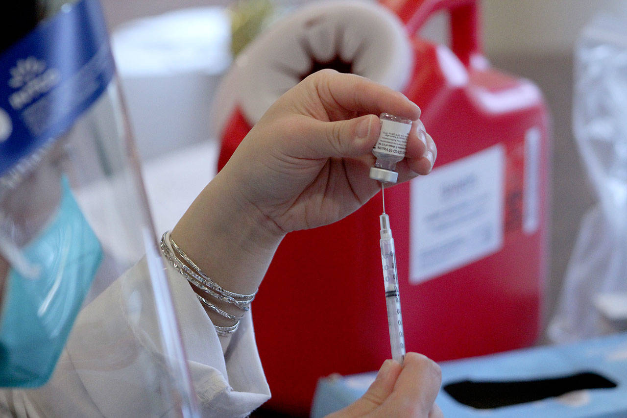 A CVS pharmacist prepares a COVID-19 vaccine at Village Green Retirement Campus in Federal Way on Jan. 26. Olivia Sullivan/Sound Publishing