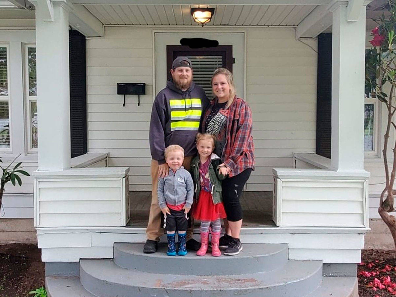 Luke, Sarah, Remi, and Ryker Lenihan in front of their new home. Contributed photo