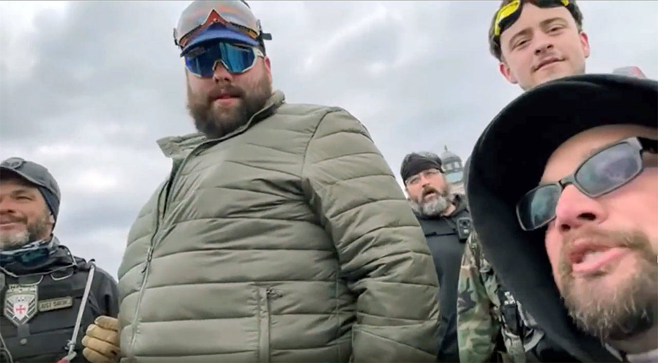 Daniel Scott (center, in green jacket) is shown in a video before the Proud Boys and other rioters stormed the U.S. Capitol building on Jan. 6 in Washington, D.C.