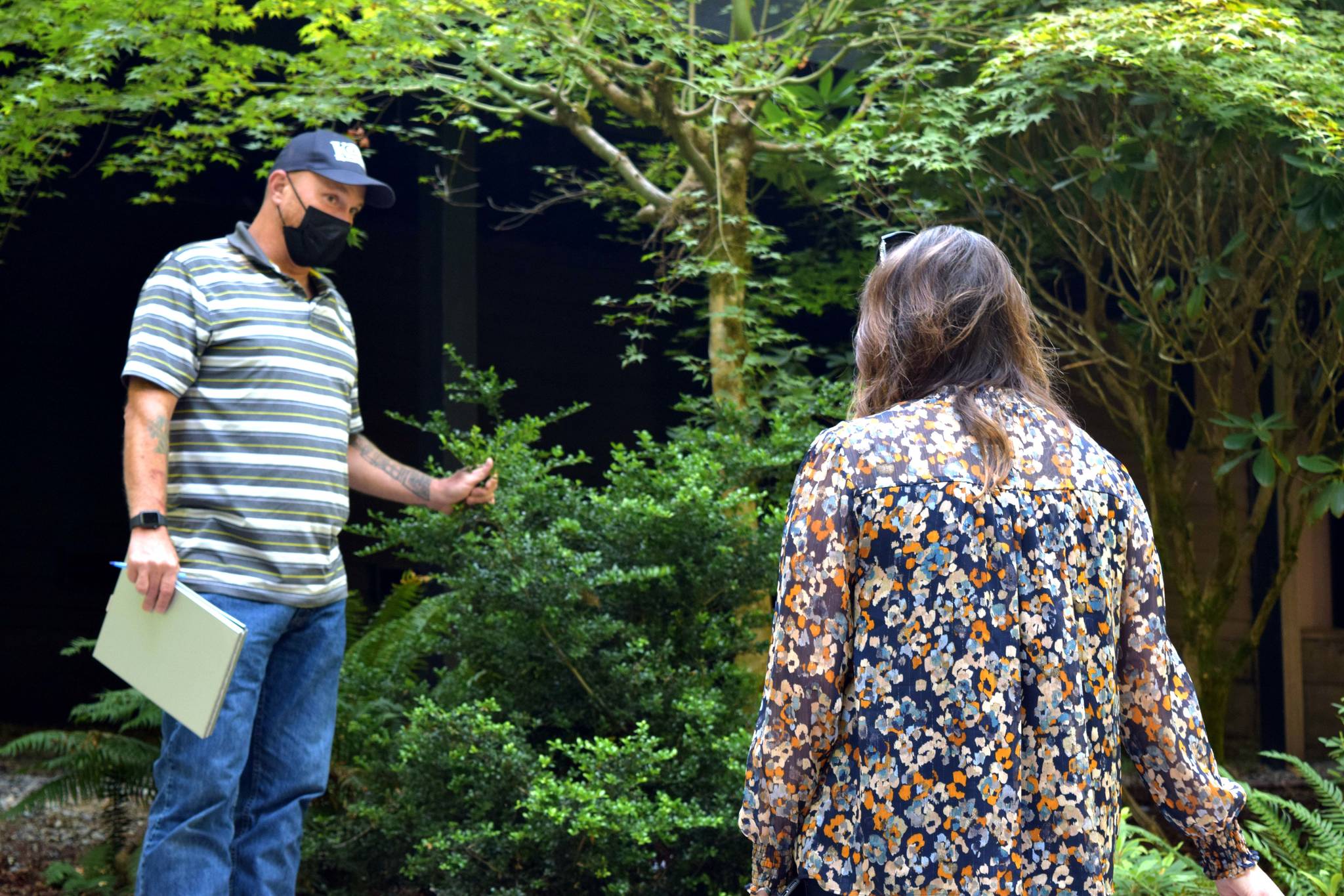 Matt Axe, the Wildfire and Forest Resiliency Coordinator with the King Conservation District, speaks to homeowner Anita Kissee-Wilder about fire reduction strategies at her home in North Bend on Aug. 24. Photo by Conor Wilson/Valley Record.