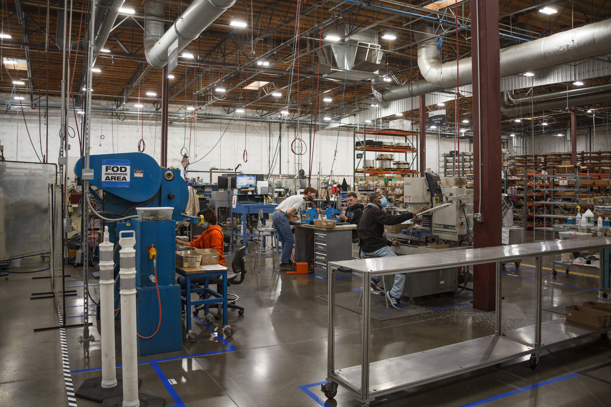 Henry Stewart-Wood / Sound Publishing
An Orion Industries mentor (center) supervises participants in one of the manufacturing processes at the Auburn factory on Nov. 16. Orion Industries is an aerospace manufacturing company that trains people with barriers to employment to enter the workforce.