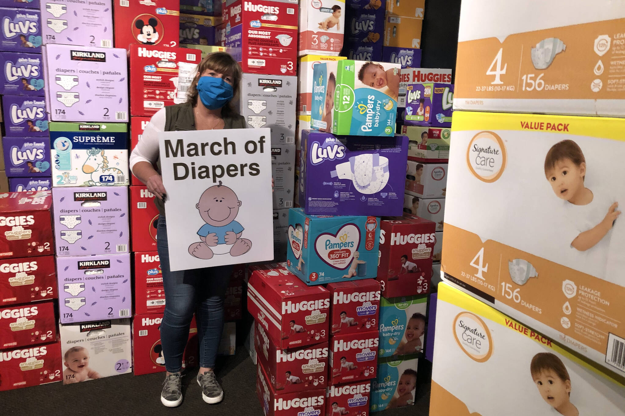 Cheryl Hurst stands among the thousands of diapers being stored at Billy McHale’s in Federal Way as part of the 2021 March of Diapers charity drive. (Sound Publishing file photo)