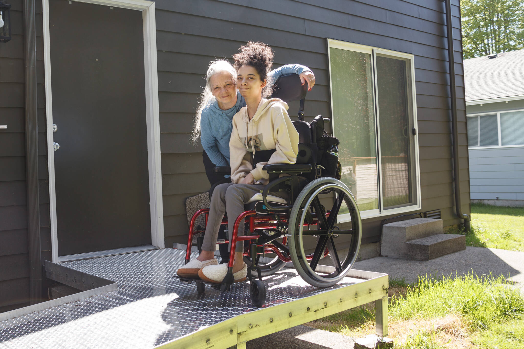 Photo by Henry Stewart-Wood/Sound Publishing
Linda Short and her daughter, Morgan Short, pose for a photo on the wheelchair ramp that was built after an Auburn school bus driver noticed Morgan needed a ramp.