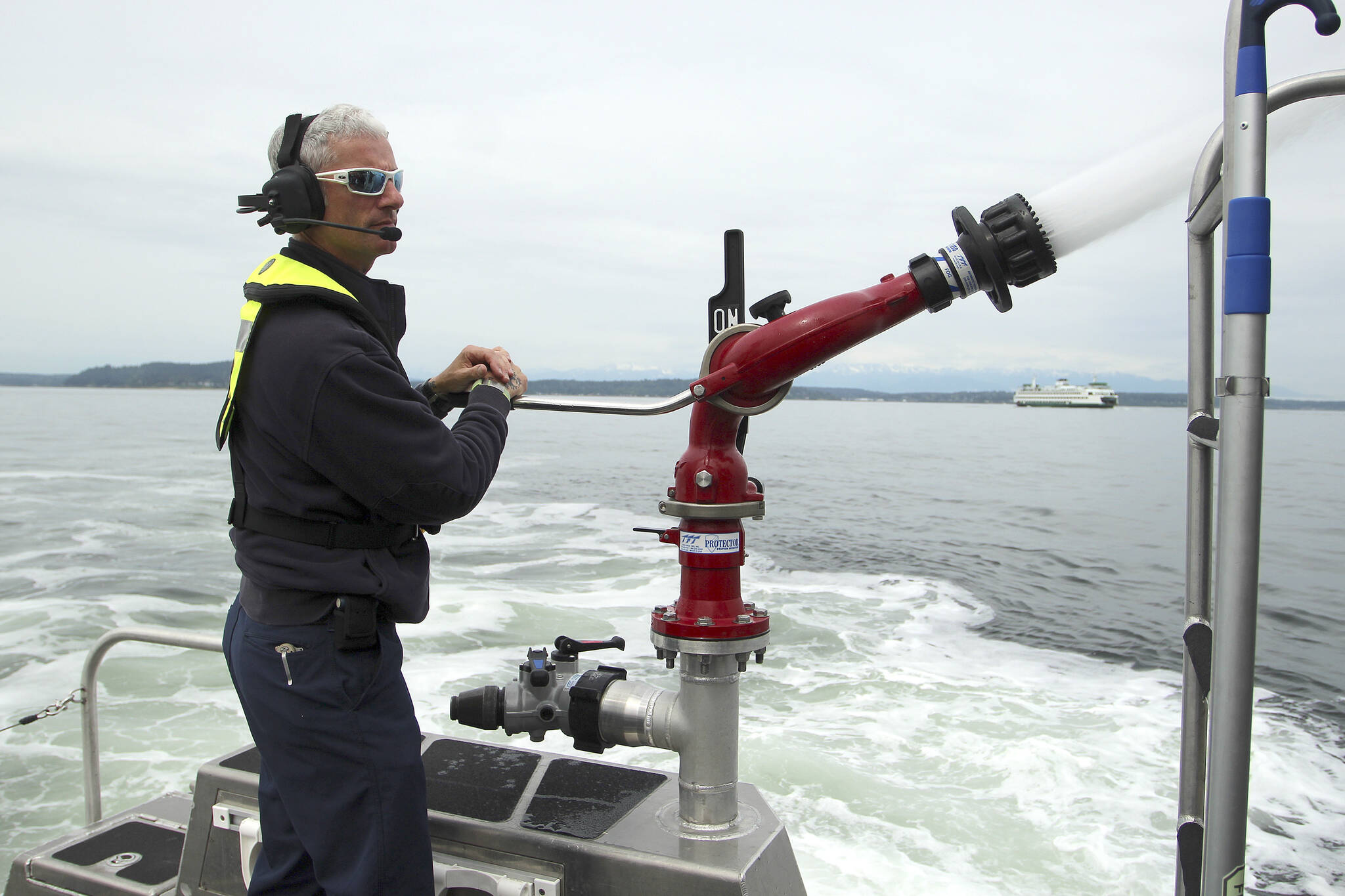 South King Fire’s Merrick McGinnis demonstrates the water canon on fire boat “Zenith” on May 26. (Olivia Sullivan/the Mirror)