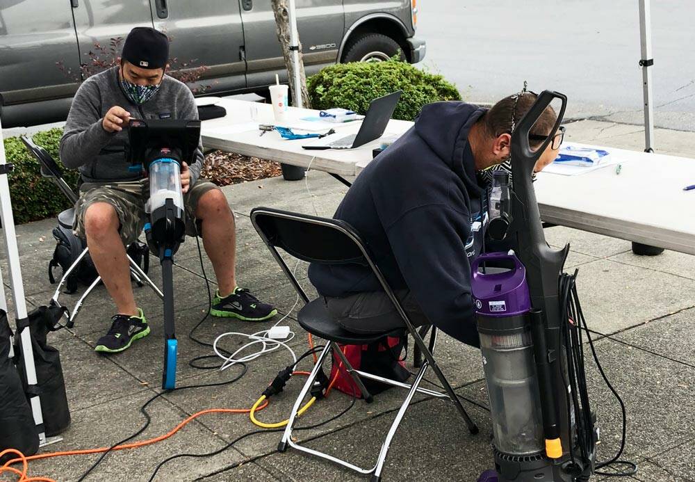Volunteers in 2021 work to repair home items like kitchen appliances and vacuum cleaners (pictured) at the county-sponsored repair events. Photo courtesy of King County Solid Waste Division.